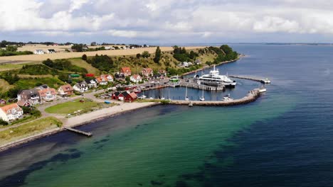 Aerial-view-paning-sideways-over-the-village-and-harbor-of-Bäckviken-on-the-island-of-Ven-in-southern-Sweden-during-a-warm-summer-day-in-tourism-season