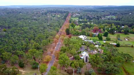 Reversing-and-rising-drone-footage-of-the-Honour-Avenue-and-rural-properties-at-Macedon,-Victoria,-Australia