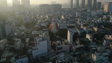 Dawn-drone-shot-flying-in-toward-the-French-colonial-church-in-Binh-Thanh,-Ho-Chi-Minh-City