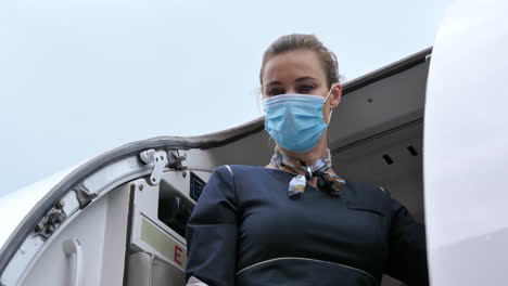 Flugbegleiterin-Mit-Coronavirus-Schutzmaske-Schließt-Flugzeugtür