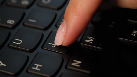Pushing-J-button-on-the-black-keyboard