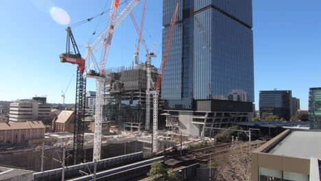 Hyperlapse-of-large-buildings-under-construction-next-to-Parramatta-train-station-showing-cranes,-men-and-vehicles-moving-around-building-site