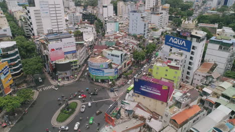 Tilt-Down-Aerial-of-busy-city-roundabout-Ho-Chi-Minh-Saigon-Slow-Motion