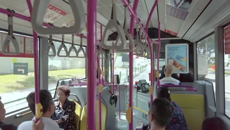 View-inside-the-public-bus-while-running-in-Singapore-city-center-with-many-passenger-in-the-bus
