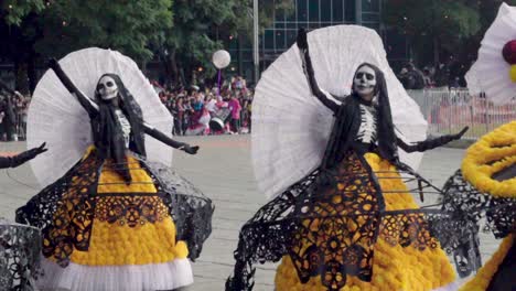 Desfile-Del-Día-De-Los-Muertos---Artistas-Bailando-Y-Girando-En-Hermosos-Vestidos-Negros-Y-Amarillos