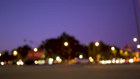 Ancient-city-square-at-night-with-cars-passing-and-motorcycles-by-in-out-of-focus