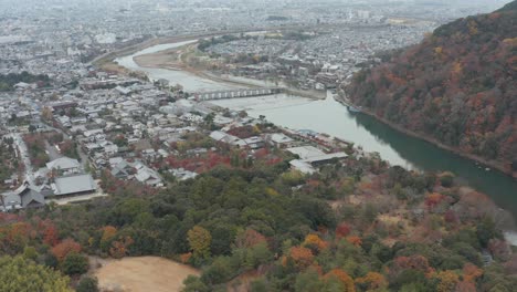 Aerial-tilt-revealing-Togetsu-Kyo-Bridge-and-Arashiyama-in-Kyoto,-Japan
