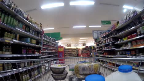 Inside-supermarket-shopping-cart-pushing-trolley-down-different-aisle-as-customers-shop-during-corona-virus-pandemic