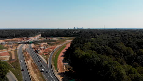 Drone-shot-of-highway-construction-with-downtown-Raleigh-North-Carolina-in-the-distance