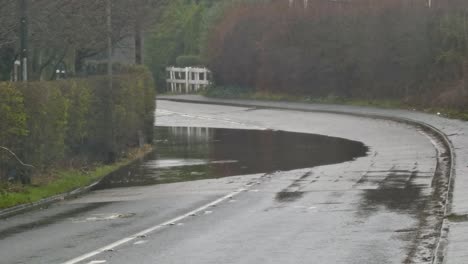 Vehicle-comes-to-stop-on-stormy-flash-flooded-road-corner-bend-UK