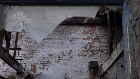 Broken-window-in-brick-built-abandoned-factory-panning-shot