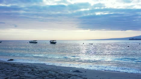 Barcos-De-Pesca-Flotando-En-Una-Tranquila-Laguna-Al-Atardecer-Con-Un-Cielo-Brillante-Con-Nubes-Coloridas-Que-Se-Reflejan-Sobre-La-Superficie-Del-Mar-En-Indonesia