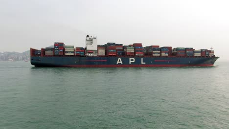 Mega-Container-Ship-leaving-Hong-Kong-port,-Aerial-view