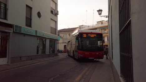 Bus-turns-tight-corner-on-narrow-European-alley-in-Seville,-Spain,-SLOWMO