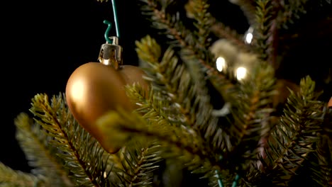 Nachdenkliches-Weihnachtsdekor-Herz-Und-Glocke,-Die-An-Einem-Baum-Hängen,-Schiebeaufnahme