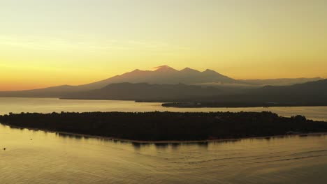 Magische-Farben-Des-Himmels-Nach-Wunderschönem-Sonnenuntergang-Mit-Gelb-Leuchtendem-Horizont-über-Bergen,-Die-Sich-Im-Meer-Um-Die-Silhouette-Der-Tropischen-Insel-Bali-Spiegeln