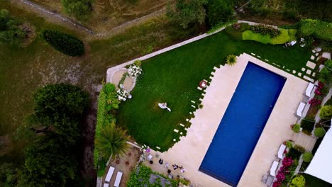 A-topdown-spining-drone-view-of-a-couple-of-married-people-dancing-in-a-garden-by-the-pool