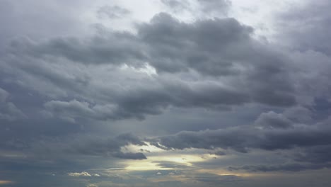 Dunkle-Gewitterwolken-Ziehen-Mit-Goldenen-Sonnenuntergangsreflexionen-Durch-Den-Himmel