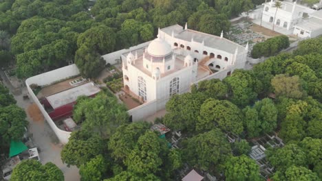 Aerial-Over-White-Mosque-Surrounded-By-Green-Trees-In-Karachi