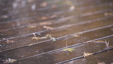 Slow-Motion-Close-Up-of-Raindrops-Hitting-Wooden-Deck