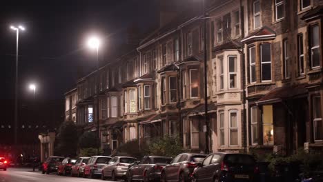 Car-Going-Past-Row-Of-Residential-Houses-At-Night-In-Bristol,-slow-motion