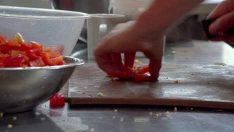 Ein-Koch-Drückt-Ein-Stück-Paprika-Flach,-Um-Es-Mühelos-In-Rote-Scheiben-Zu-Schneiden-Und-Für-Eine-Große-Mahlzeit-Vorzubereiten