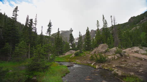 Hiker-sitting-on-rock-near-stream