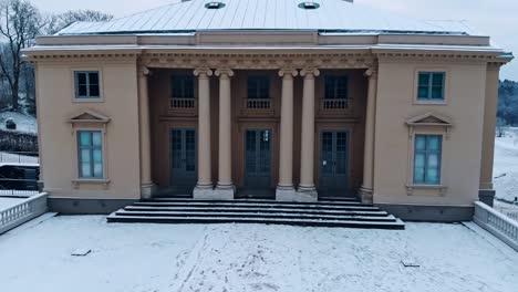 Close-up-view-of-Gunnebo-Palace-from-drone-flying-backwards-into-the-snow-covered-garden