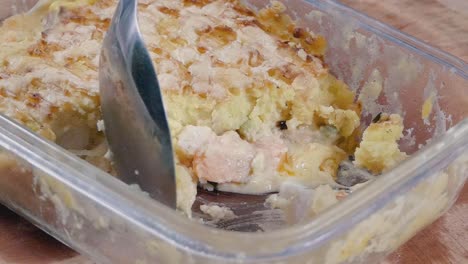 Close-Slow-Motion-Shot-of-Spooning-Fish-Pie-from-a-Cooking-Dish
