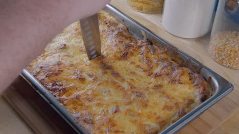 Using-a-Knife-to-Slice-into-a-Freshly-Cooked-Lasagne-on-the-Kitchen-Counter