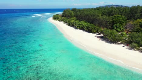 Quiet-exotic-beach-with-white-sand-washed-by-turquoise-lagoon-flows-on-empty-cape-of-tropical-island-with-lush-vegetation-in-Bali