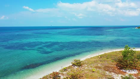 Costa-De-Las-Bermudas,-Pequeña-Playa-De-Arena,-Agua-De-Mar-Turquesa-Y-Cielo-Azul-Brillante-Con-Nubes-Esponjosas