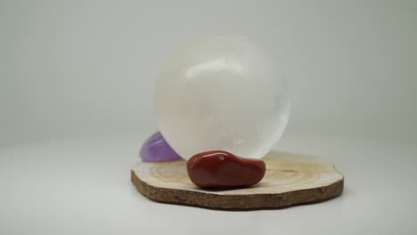 A-Round-White-Crystal-Ball-On-Top-Of-A-Wood-Craft-With-Two-Gem-Stones-On-Both-Sides---Close-Up-Shot