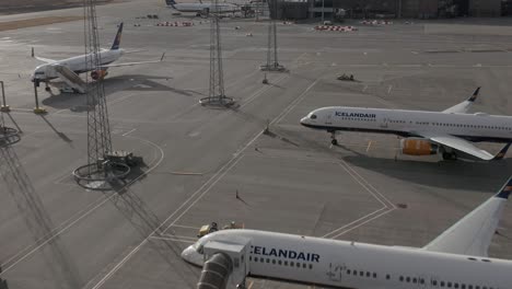 Grounded-fleet-of-Icelandair-on-tarmac-at-Reykjavik-airport-on-sunny-day,-aerial