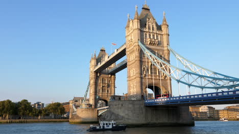 A-Boat-Passing-By-On-The-River-Thames-Under-The-Tower-Bridge,-One-Of-The-Famous-Landmarks-In-London,-United-Kingdom---full-shot