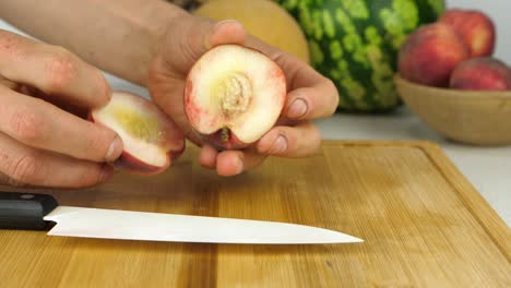 Well-worked-hands-prepare-a-peach-for-slicing