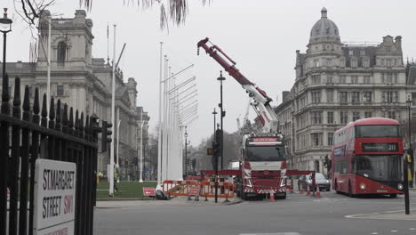 Workers-Installing-Flagpole-In-Parliament-Square-Gardens-With-London-Bus-Going-Past