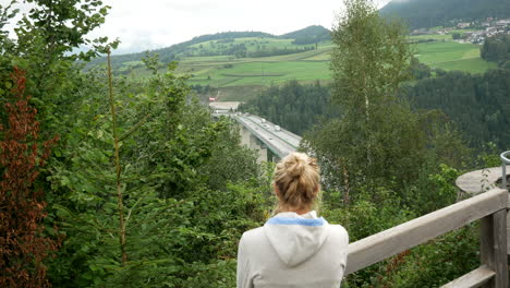 Young-blond-girl-enjoying-beautiful-wide-view-of-Brenner-Motorway-in-Austria-during-holiday-trip