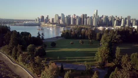 Die-üppigen-Grünen-Bäume-Am-Brockton-Point-Des-Stanley-Parks-Mit-Blick-Auf-Die-Skyline-Der-Innenstadt-Von-Vancouver-Und-Coal-Harbour-Während-Eines-Wunderschönen-Sonnenaufgangs-In-British-Columbia,-Kanada
