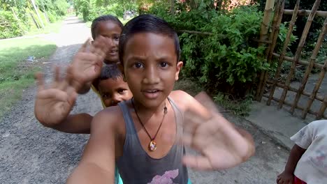 Der-Arme-Asiatische-Junge-Hält-Die-Kamera-Und-Alle-Kinder-Lächeln-Und-Winken-Mit-Den-Händen,-Zeitlupenaufnahme