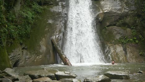 Man-Swimming-at-Basin-of-Puncea-Waterfall,-Slow-Motion-Wide-Shot-Full-HD