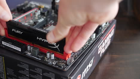 A-computer-repair-technician-installing-RAM-sticks-into-an-MSI-gaming-motherboard-during-a-custom-pc-build