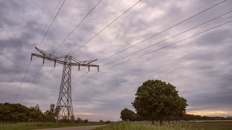 Electricity-pylon-during-sunset-with-fast-moving-clouds-changing-direction-and-color