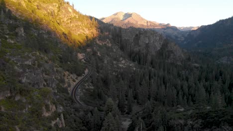 Aerial-view-of-a-car-driving-down-Sonora-Pass-in-the-Sierra-Nevada-mountain-range-at-sunset
