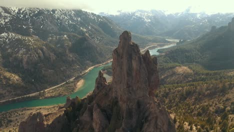 Aerial-shot-orbiting-an-impressive-rock-formation-with-a-river-valley-on-background-in-Patagonia-region,-Argentina