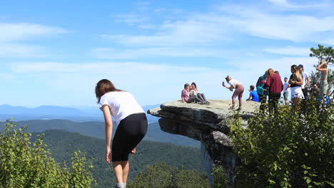 Two-girls-posing-for-a-photo-with-their-dog-on-top-of-the-McAfee-Knob-in-Virginia