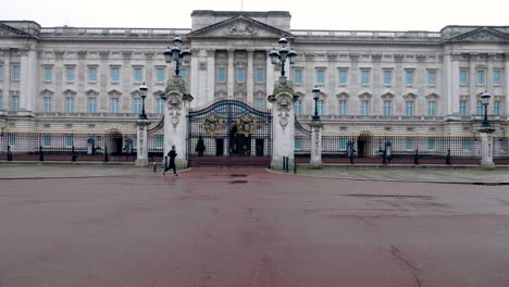 Slow-motion-shot-of-two-people-jogging-right-in-front-of-the-famous-Buckingham-Palace,-London