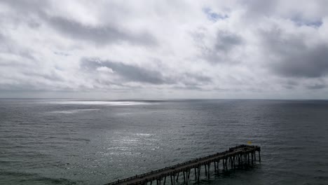 Relaxing-Scene---Ocean-Pier-with-Beautiful-Clouds-over-Horizon,-Aerial-Drone-Seascape
