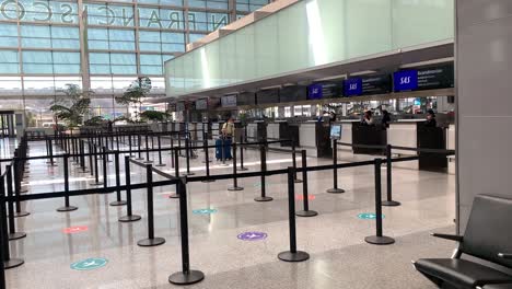 Leere-Check-in-Warteschlange-Am-Flughafen-Aufgrund-Einer-Coronavirus-Pandemie,-Maskiertes-Mädchen