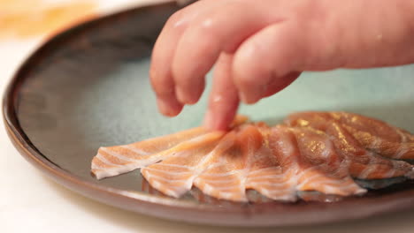 Laying-Thin-Slices-Of-Fresh-Raw-Salmon-In-A-Plate---close-up,-slow-motion